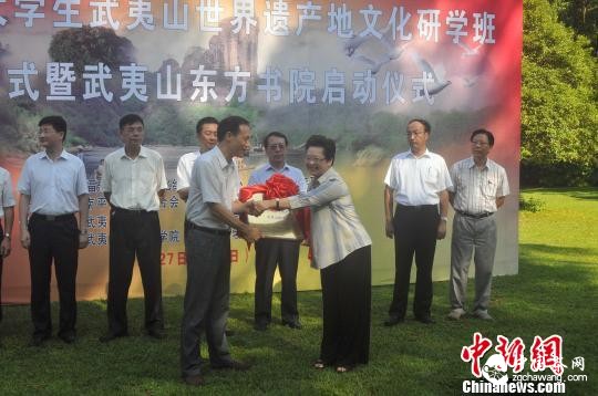 7月28日，2015年閩港大學(xué)生武夷山世界遺產(chǎn)地文化研學(xué)班啟動(dòng)儀式上，武夷山風(fēng)景名勝區黨工委副書(shū)記余澤嵐(左)與福建省國際文化中心交流秘書(shū)長(cháng)袁碧鴻(右)進(jìn)行授牌儀式?！堺惥?攝